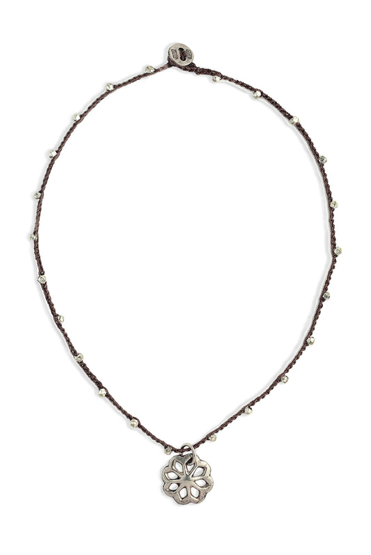 A bohemian-style necklace featuring a brown hand-crocheted cord adorned with small silver beads, and a sterling silver antique rosette button by On U Jewelry, Richmond, VA.